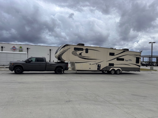 Grand Design fifth wheel tow under storm clouds