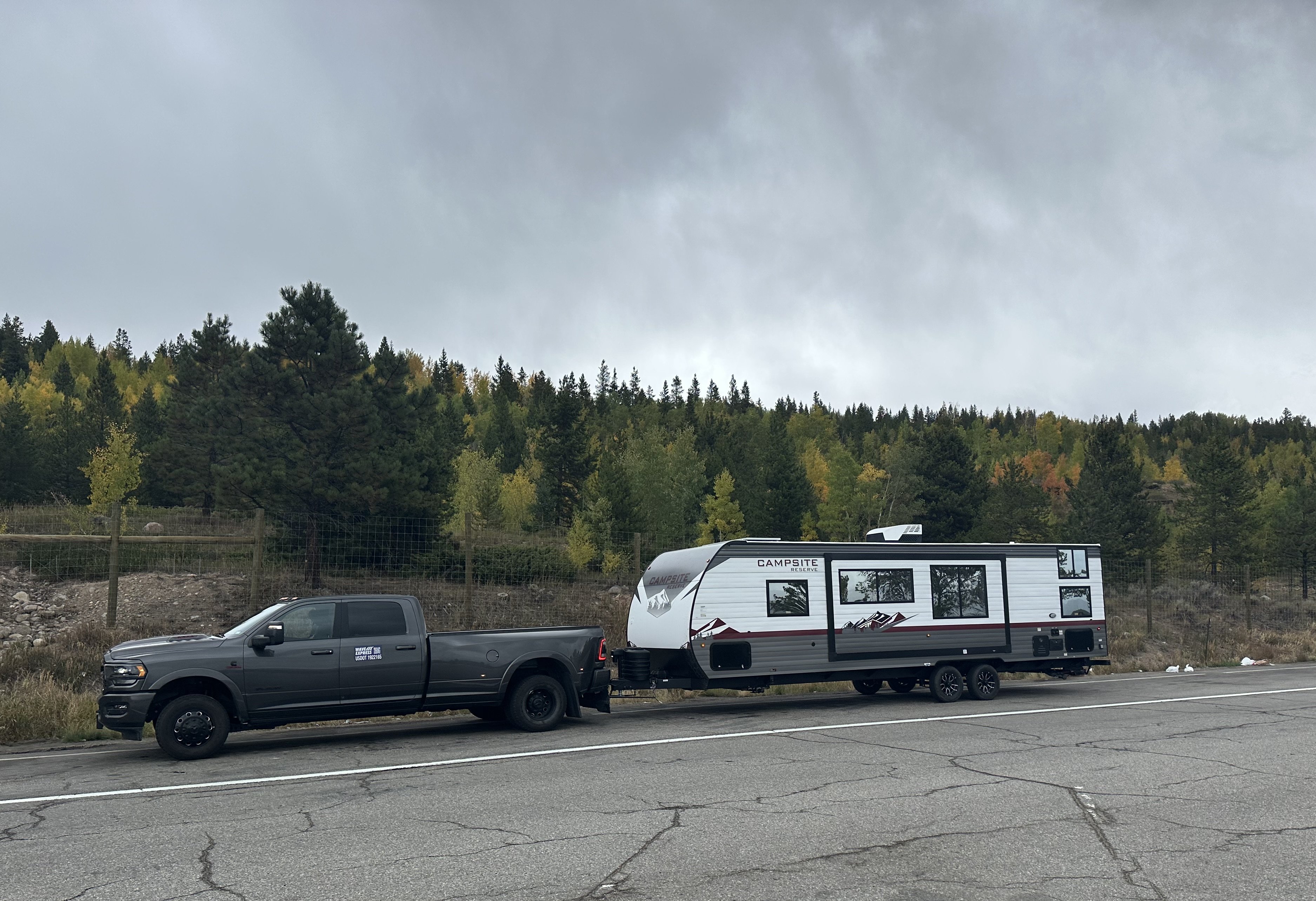 Mission Ready Transport Ram 3500 towing a travel trailer on an open road during an RV transport job
